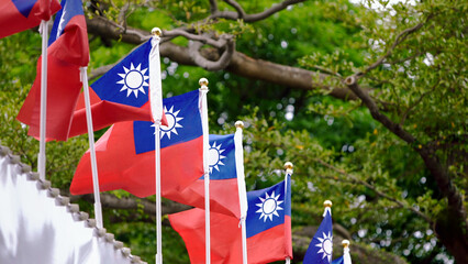 Taiwan flags waving with lush greenery in background, Taiwanese national pride