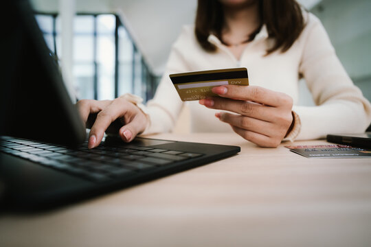 Close-up of a woman using a smartphone and holding a credit card for online shopping or payment, symbolizing digital finance and modern lifestyle. - Powered by Adobe