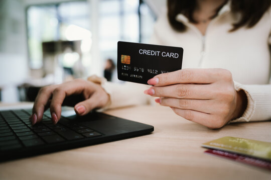 Close-up of a woman using a smartphone and holding a credit card for online shopping or payment, symbolizing digital finance and modern lifestyle.