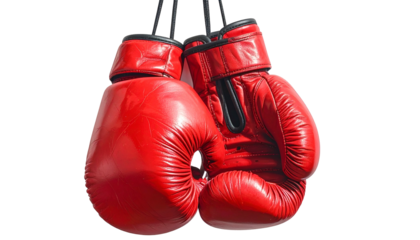 Pair of bright red boxing gloves, hanging by their laces, against a clean black background