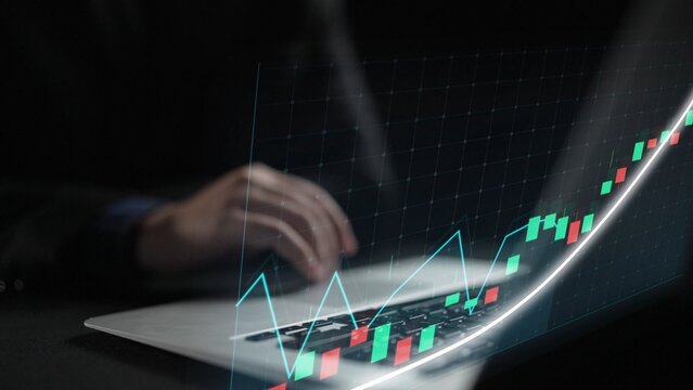 A dedicated trader focuses on a laptop screen showcasing financial growth trends with colorful candlestick patterns, emphasizing performance analysis and investment strategies. Copula