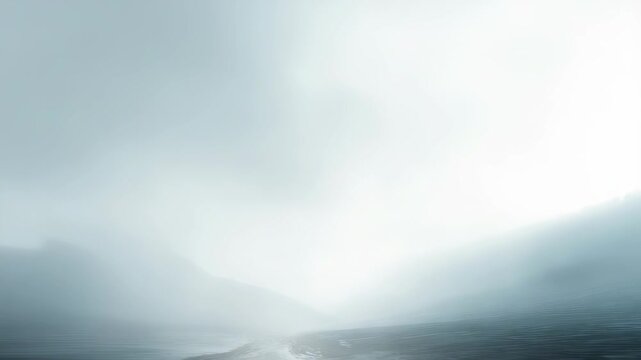 A breathtaking view of misty mountains enveloped in gentle fog, with subtle light illuminating the horizon. The tranquil landscape inspires a sense of peace and quiet reflection