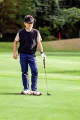 ゴルフを楽しむ日本人のミドル男性