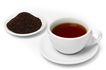 White cup of freshly brewed Ceylon Dimbula Broken Orange Pekoe tea on saucer with pile of dried black tea leaves on plate, isolated on white background