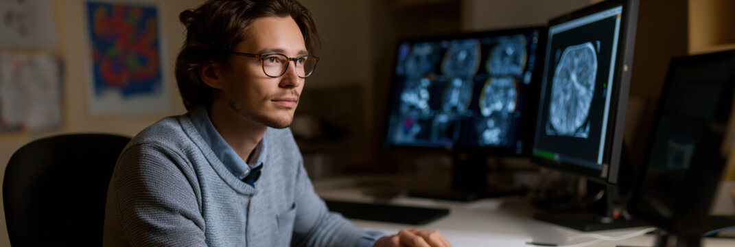 A pensive programmer works intently with medical imaging, showcasing the intersection of technology and healthcare, emphasizing the importance of innovation in medicine. - Powered by Adobe