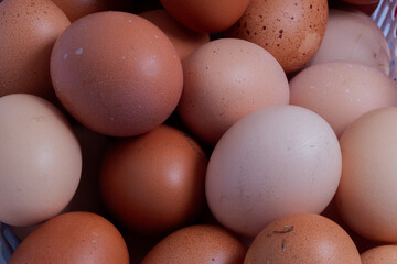 Close-up of fresh brown chicken eggs with natural texture and color variations, organic farm product background, healthy food concept, natural protein source, rustic kitchen ingredient, eco-friendly f