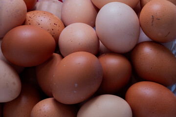 Close-up of fresh brown chicken eggs with natural texture and color variations, organic farm product background, healthy food concept, natural protein source, rustic kitchen ingredient, eco-friendly f