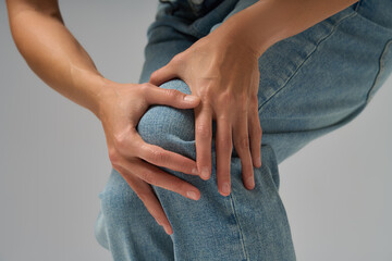 Close-up of woman touching her knee showing discomfort and joint pain