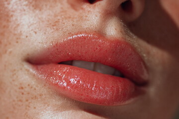 Naklejka premium Close up beauty shot of natural lips with soft pink tone and visible freckles. Clean makeup look showing lip texture, hydration and skincare focused cosmetic effect.