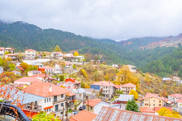 Panoramic High-Angle View of Avdella Village, Grevena, Greece, Nestled in the Misty Pindos Mountains with Traditional Houses and Autumn Foliage