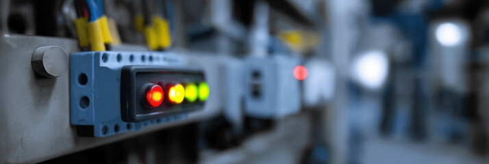 A detailed view of a control panel showcasing illuminated indicators and buttons, reflecting the intricate technology managing complex systems in a facility.