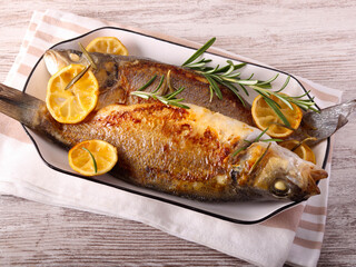 Seabass fish with lemon and rosemary on plate