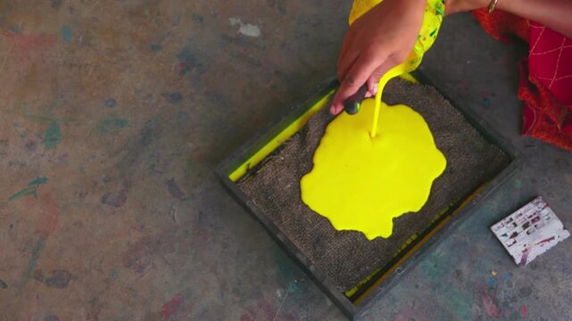 "Artisan Pouring Yellow Paint into Block Printing Machine, Close-Up 4K Video, Traditional Textile Printing, Handcrafted Workshop Footage, Creative Handwork in Action"