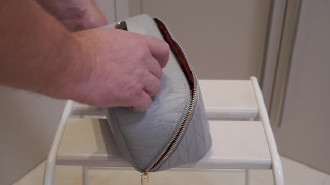 Quick Zip: Hand Distinctly Opens and Closes Gray Leather Vanity Case.