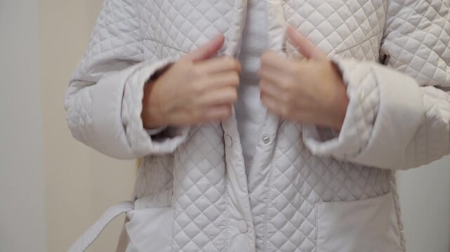 Relieved Woman Undoes Quilted Jacket Snaps with a Crisp Click After Coming Home