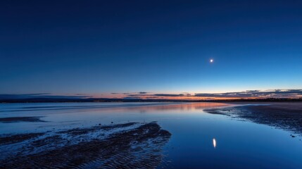 Obraz premium A tranquil evening scene shows calm waters reflecting the colors of twilight. A crescent moon shines brightly above, creating a peaceful atmosphere at dusk.