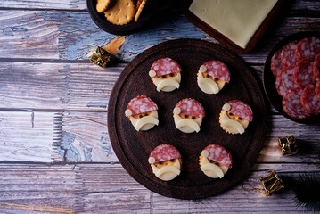 Salami sausage and cheese slices and crackers in the form of Santa Claus for Christmas holidays