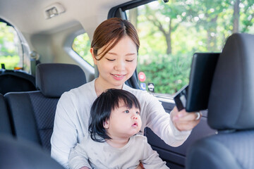 小さい子供と一緒にタクシーに乗るお母さん