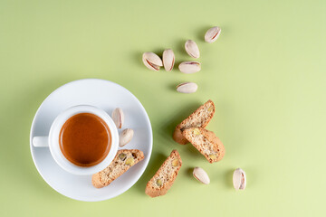 Overhead shot of a hot espresso with crispy Italian cookies, baked with pistachios, ready to be dipped and enjoyed