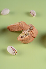 Traditional Italian cantucci with visible pistachio pieces, arranged artfully on a light green background, ideal for dessert themes