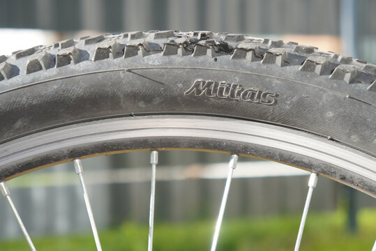 Close-up of a damaged Mitas bicycle tire on a mountain bike wheel