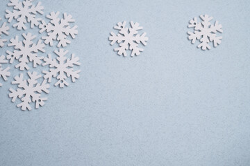 Winter background: clean white snowflakes on a soft pastel blue surface with copy space.
