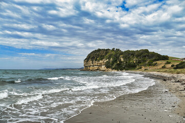 View of beach, rough sea and Fossil Bluff, a sandstone formation with millions of marine fossils at Wynyard, Tasmania, Australia
