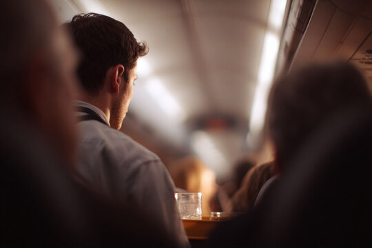 Atmospheric image of a man on public transport, perhaps contemplating. Good for themes of travel, solitude, or urban life. Cinematic, warm tones.