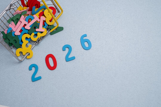 Planning goals for 2026: miniature shopping basket spilling out colorful letters and numbers on a pastel background.