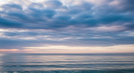 Serene seascape with a dramatic cloudy sky. Peaceful horizon over calm ocean water. Minimalist nature scenery for wellness and meditation. Conceptual image of tranquility and mindfulness