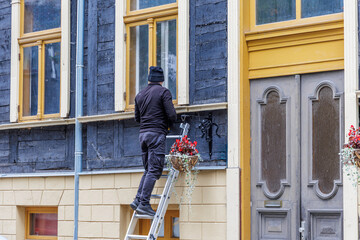Worker on Ladder Installing Decoration