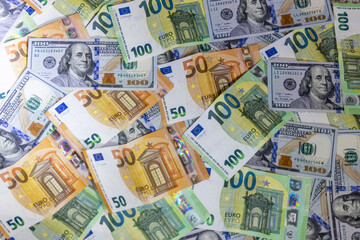 US dollar and Euro banknotes arranged on flat surface featuring currency details, denominations and textures representing finance, economy, global trade, investment, banking and international monetary