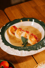 Dessert of sweet bananas in creamy sauce served on a wooden table