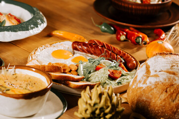 Colorful breakfast spread with eggs, sausages, and fresh vegetables on a rustic table