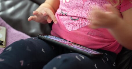 Little girl engages with digital tablet on the couch during a quiet afternoon at Home, learning and exploring new interactive games - Powered by Adobe