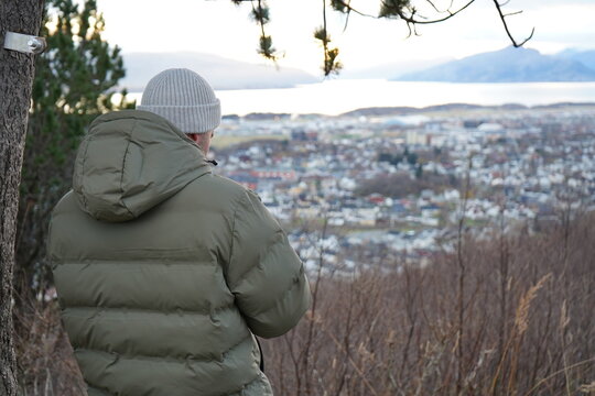 man in winter park stands on the observation deck