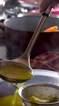 Slow motion. The cook, pours the broth over the chickpeas through a strainer.