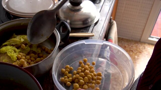 Slow motion. Grandmother pours the chickpeas from the stew into a plastic container.