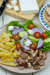 Plato combinado con carne, patatas fritas, ensalada y queso feta