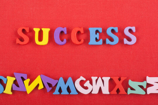 SUCCESS word on red background composed from colorful abc alphabet block wooden letters, copy space for ad text. Learning english concept.