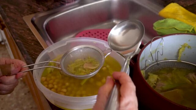  Closeup. The cook pours the broth over the stew through a strainer.