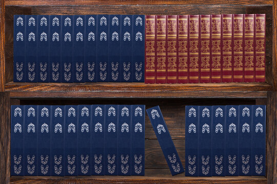 Books on the bookshelves in the library. Dark wood bookcase.