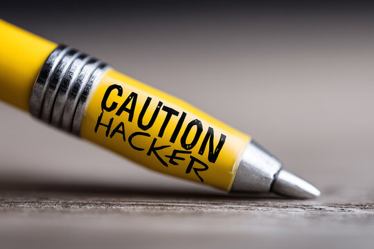 Close up, data unlocking hackers sign with written "CAUTION HACKER"