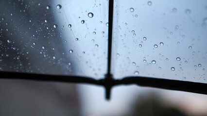 A transparent umbrella and a street out of focus, an autumn city in cloudy weather, melancholic bokeh