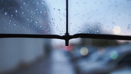 A transparent umbrella and a street out of focus, an autumn city in cloudy weather, melancholic bokeh