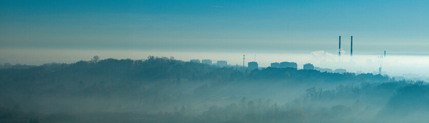 Misty Blue Panorama: Industry and Mountains Over a Sea of Fog