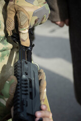 Obraz premium A military man with gloves holding a weapon. Preparation of military equipment.