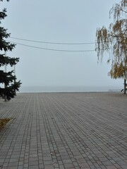Embankment of the Dnipro River in fog and dusk