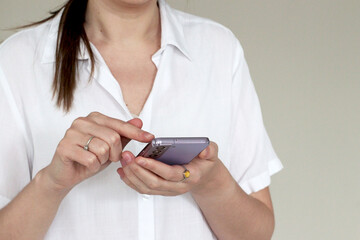 Woman in a white shirt using smartphone for work communication. Concept of business connection, digital lifestyle, and productive professional routine in a modern office.