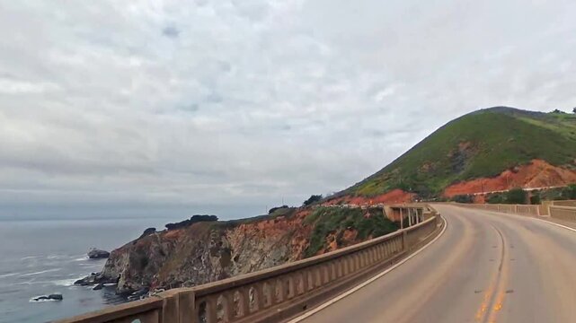 Video driving across Bixby Bridge on Highway 1 near Big Sur, capturing panoramic coastal views and scenic California coastline.